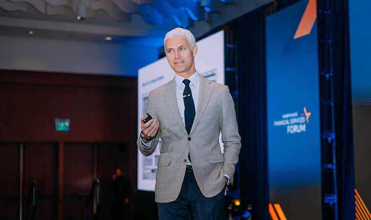 Keynote speaker walking the stage at the 2025 Forum